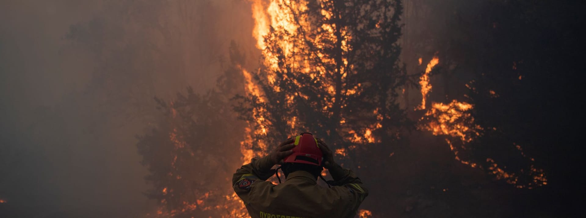 Ein Feuerwehrmann rückt seinen Helm im Dorf Varnava während eines Waldbrandes zurecht, während in vielen Regionen des Landes aufgrund der hohen Temperaturen und Windgeschwindigkeiten höchste Alarmbereitschaft herrscht.