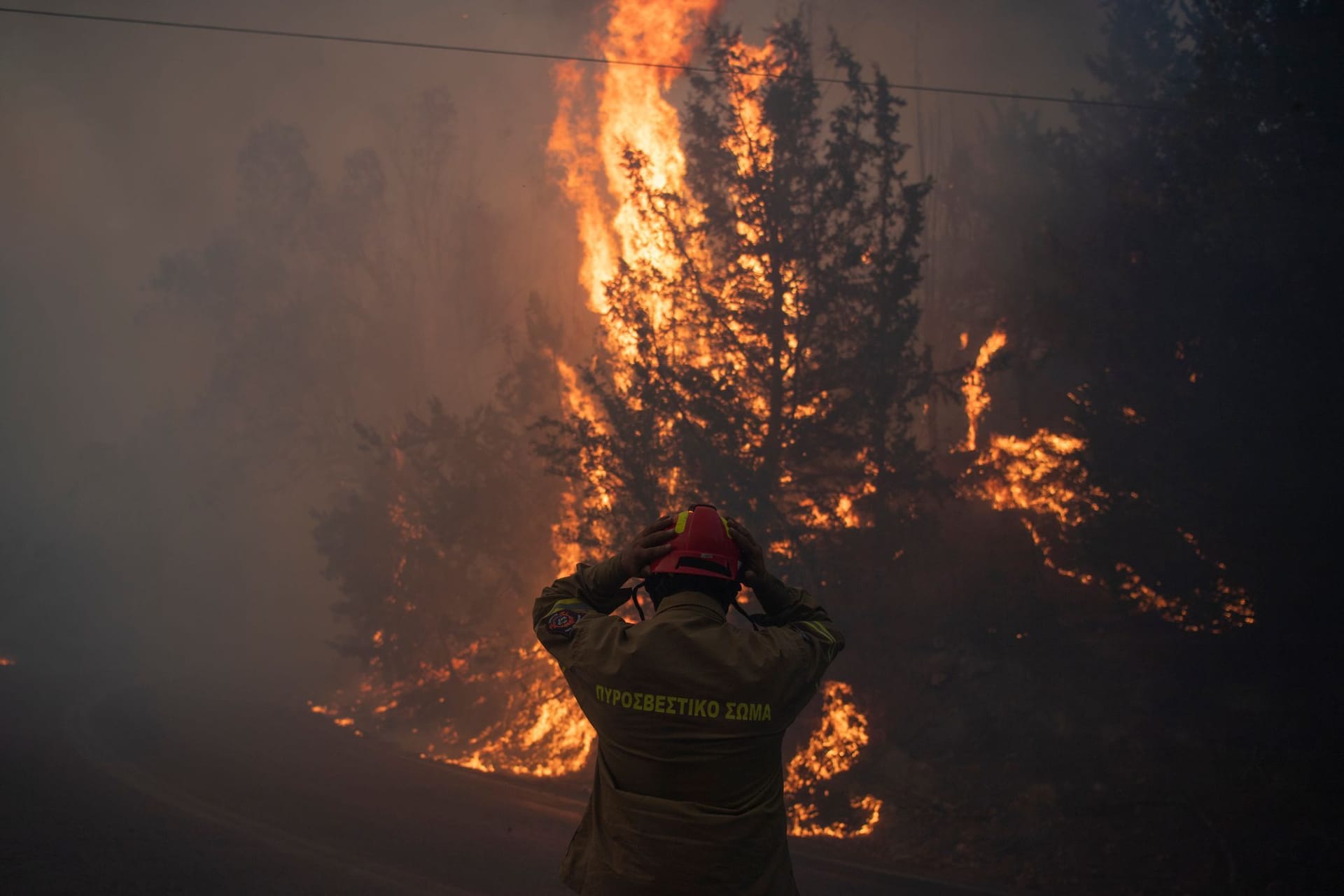 Ein Feuerwehrmann rückt seinen Helm im Dorf Varnava während eines Waldbrandes zurecht, während in vielen Regionen des Landes aufgrund der hohen Temperaturen und Windgeschwindigkeiten höchste Alarmbereitschaft herrscht.