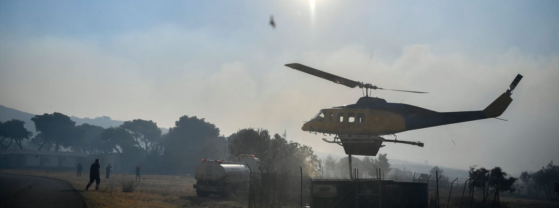 Ein Hubschrauber füllt seinen Wassertank in der Nähe von Penteli, nordöstlich von Athen, Griechenland, auf.