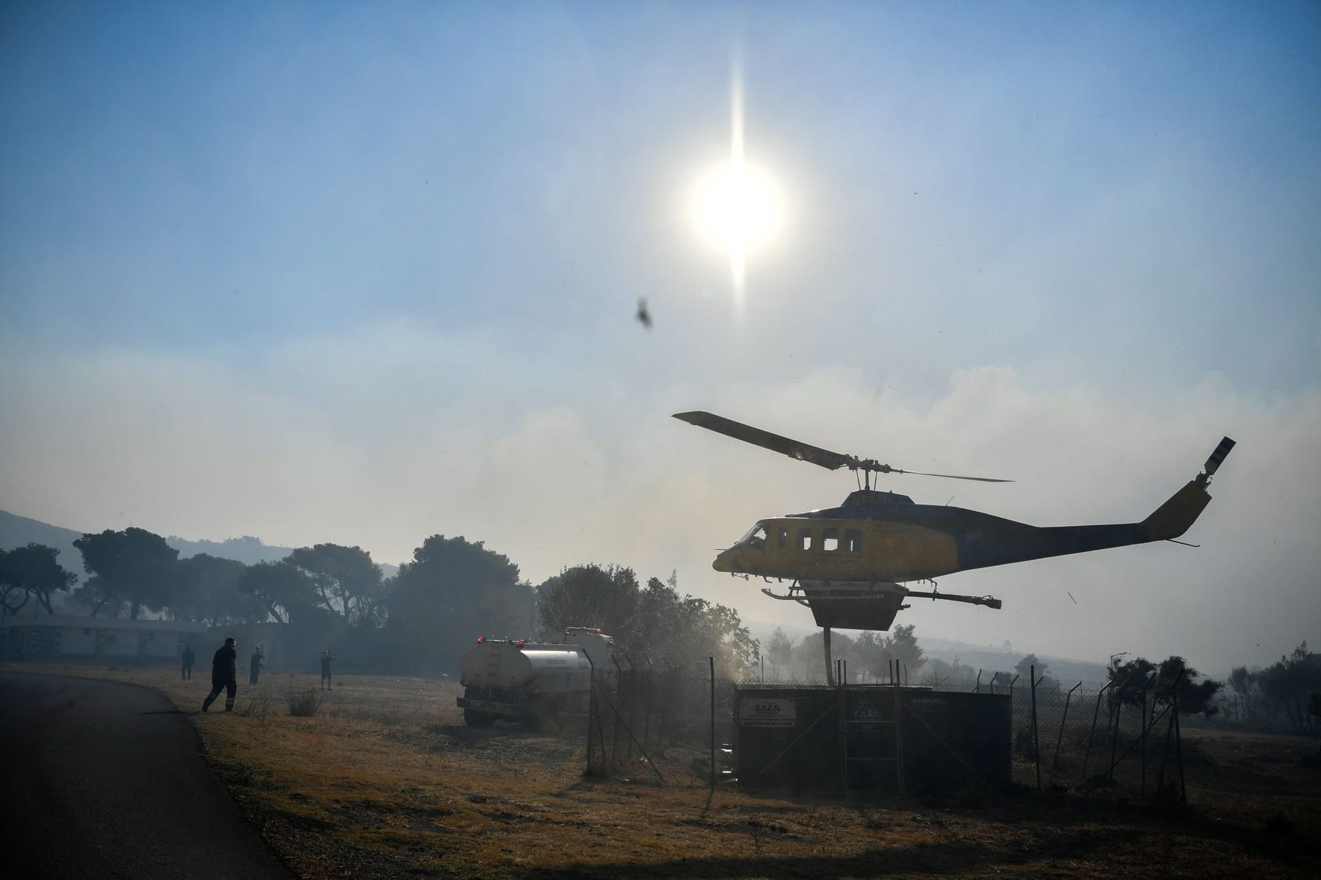 Ein Hubschrauber füllt seinen Wassertank in der Nähe von Penteli, nordöstlich von Athen, Griechenland, auf.