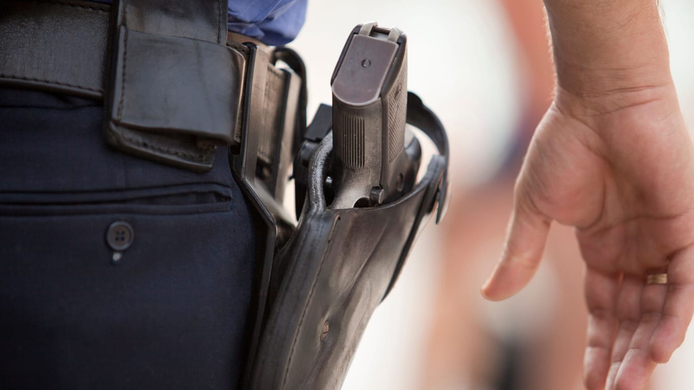 Ein Polizist mit einer Waffe (Symbolbild): In Berlin mussten Polizisten bei einem Einsatz ihre Waffen ziehen.