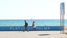 Eine Urlauberin steht an der Promenade am Strand von Playa de Palma und schaut aufs Meer (Archivbild): Auf Mallorca sind zwei Menschen aufgrund der Hitze gestorben.
