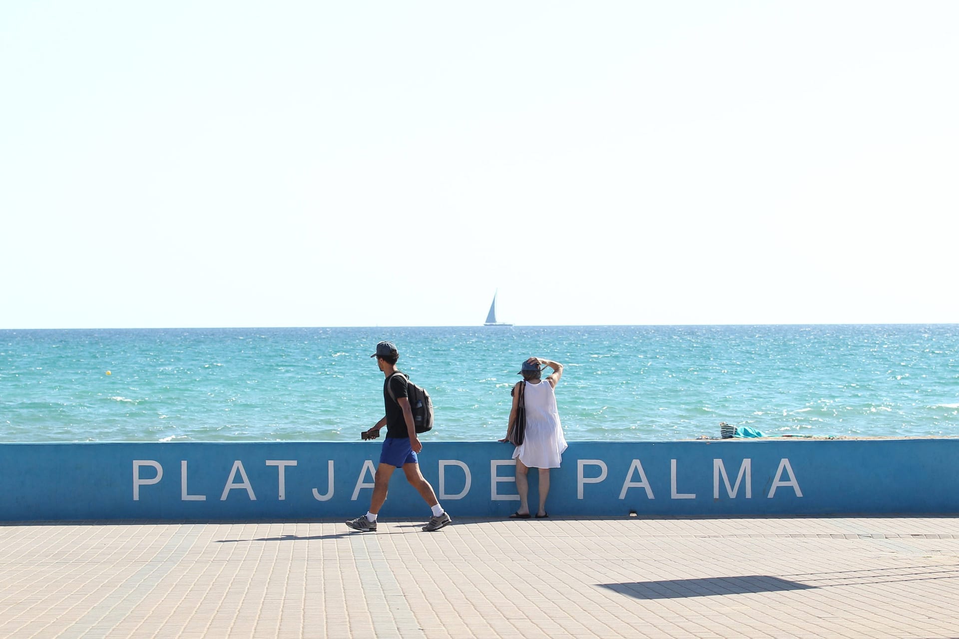 Eine Urlauberin steht an der Promenade am Strand von Playa de Palma und schaut aufs Meer (Archivbild): Auf Mallorca sind zwei Menschen aufgrund der Hitze gestorben.