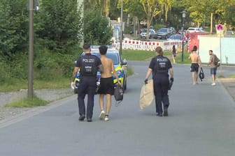 Einsatz am Freibad: Die Polizei bringt einen jungen Mann zu einem Streifenwagen.