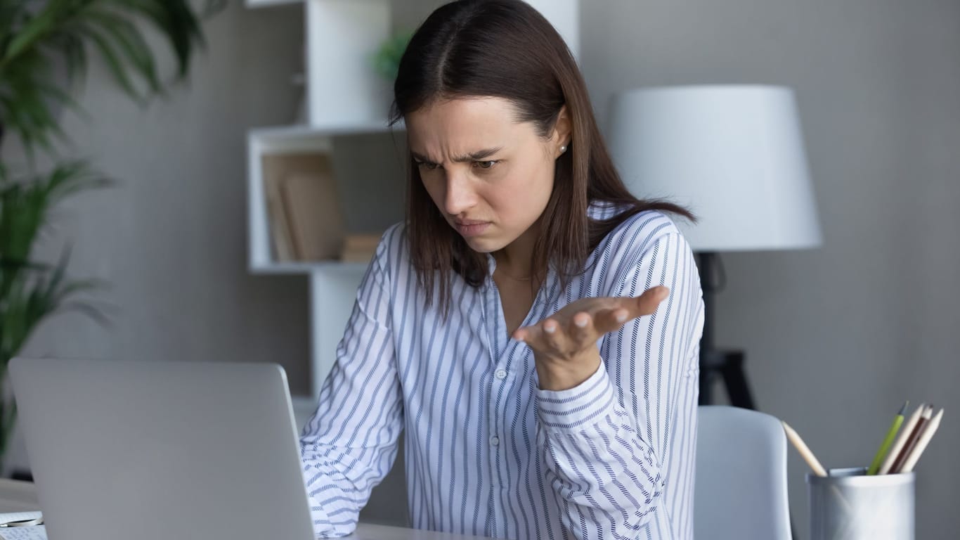 Frau am Laptop ärgert sich über eine Nachricht