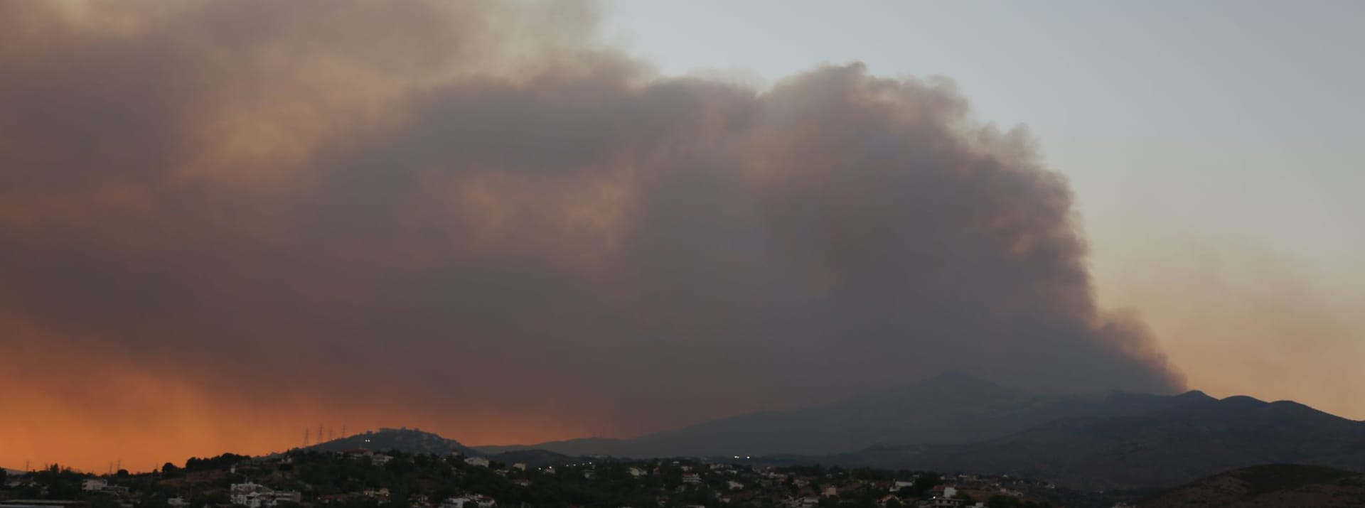 Dunkler Rauch steigt auf über einem großen Waldbrand in Varnavas, etwa 35 km von Athen entfernt.