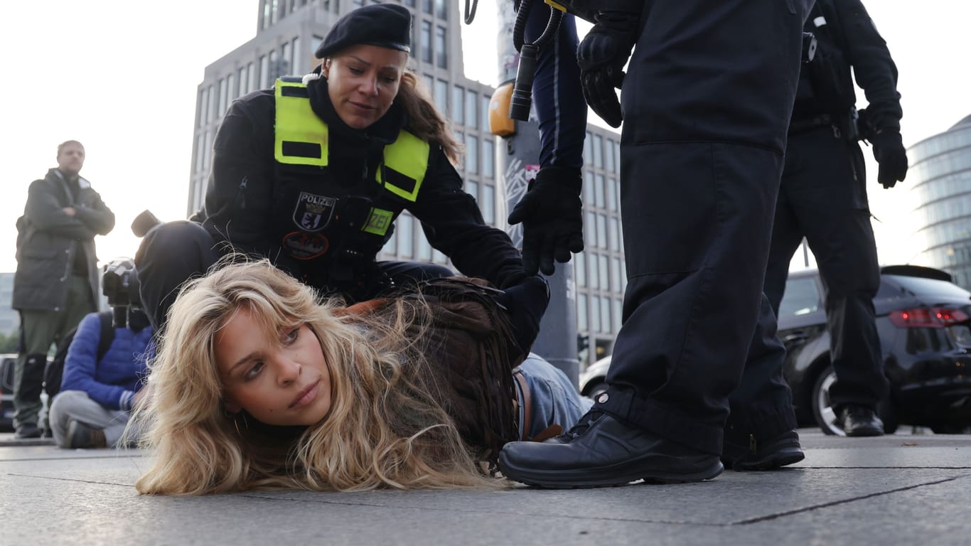 Eine Klimaaktivistin wird in Berlin festgesetzt (Archivbild): Nach neuen Blockaden an Flughäfen fordern Politiker härtere Strafen.