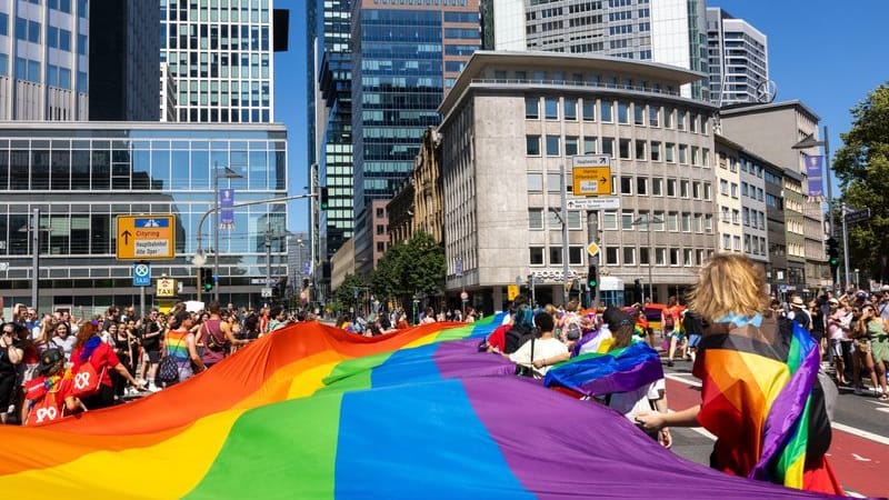 Menschen feiern mit einer großen Regenbogenfahne beim Christopher Street Day (CSD) Frankfurt: Das diesjährige Motto lautet "Wir sind extrem liebevoll".