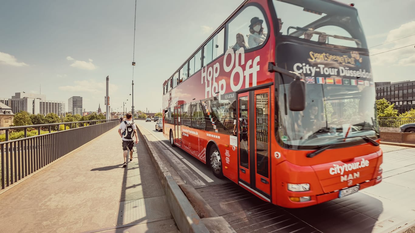 23 July 2022, Dusseldorf, Germany: The double-decker Hop on Hop off tourist bus transports travelers around the old city of Europe