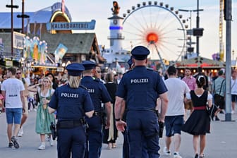 Polizeibeamte laufen über das Oktoberfest (Archivbild): Mehr als 600 Beamte werden in diesem Jahr auf dem Festgelände auf der Theresienwiese im Einsatz sein.