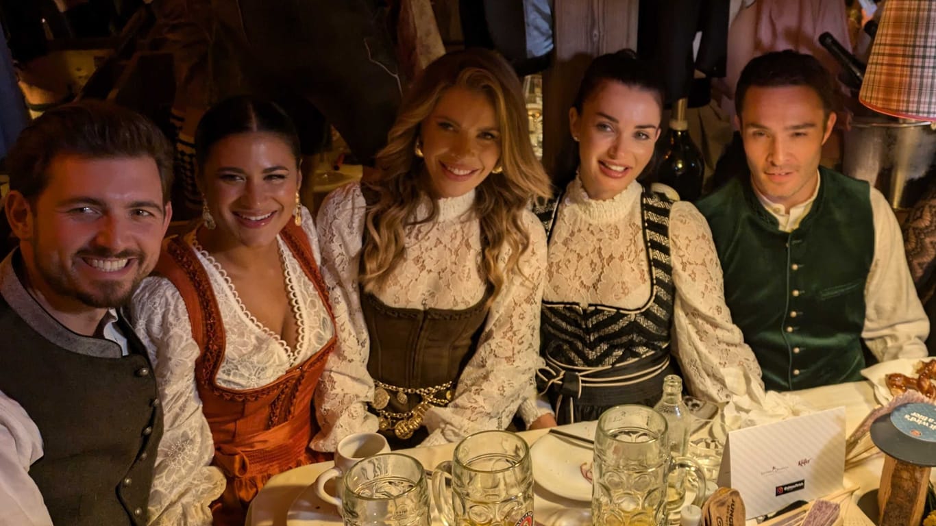 Schauspieler Ed Westwick (rechts) neben seiner Ehefrau Amy Jackson und Victoria Swarovski (Mitte) am Tisch in Käfers Wiesn-Schänke. (Quelle: Kern)