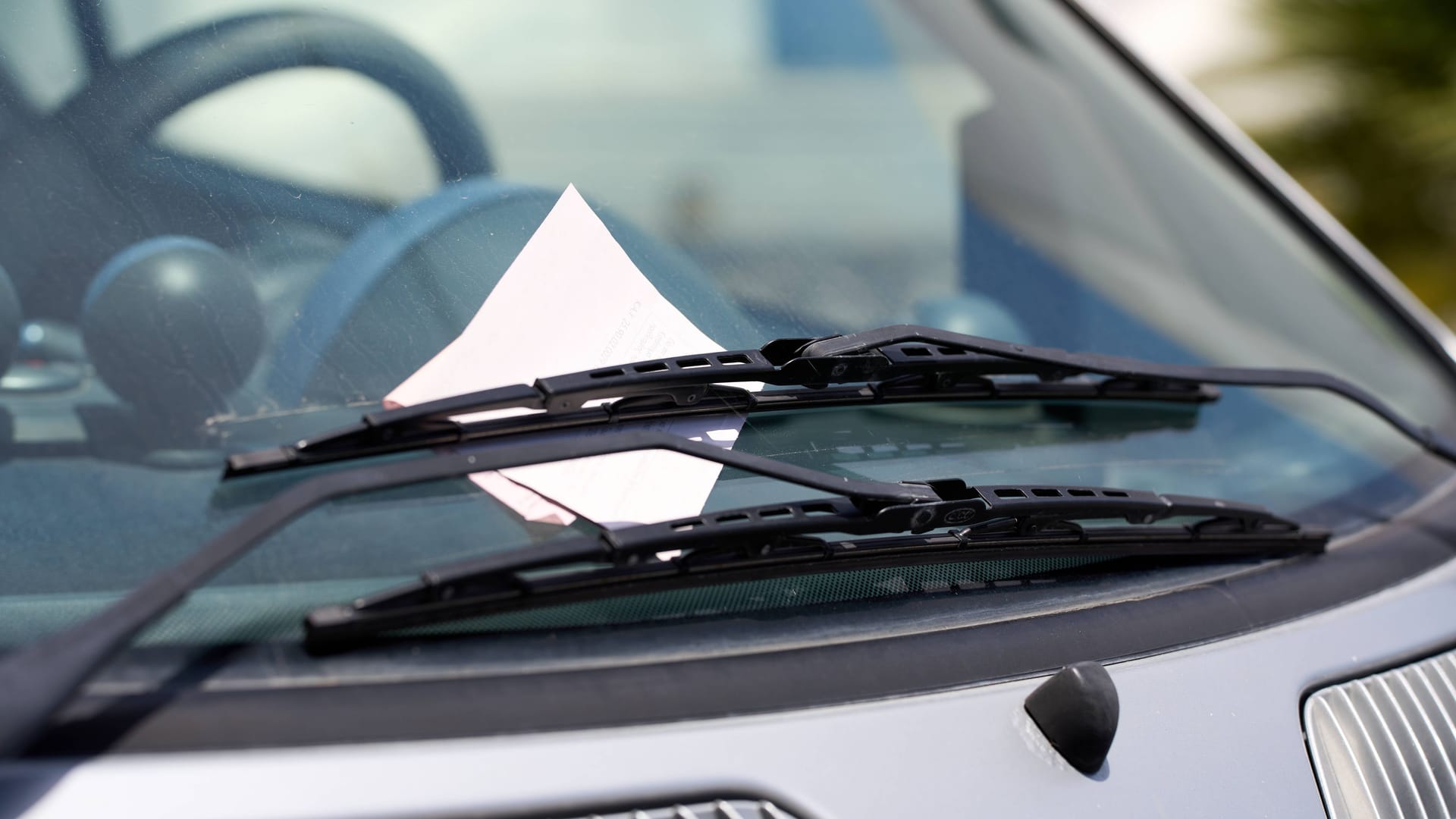 Strafzettel an der Windschutzscheibe eines Autos (Symbolbild): In den niedersächsischen Kommunen können Beamte Falschparker bald per App melden.