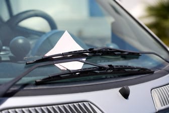 Strafzettel an der Windschutzscheibe eines Autos (Symbolbild): In den niedersächsischen Kommunen können Beamte Falschparker bald per App melden.