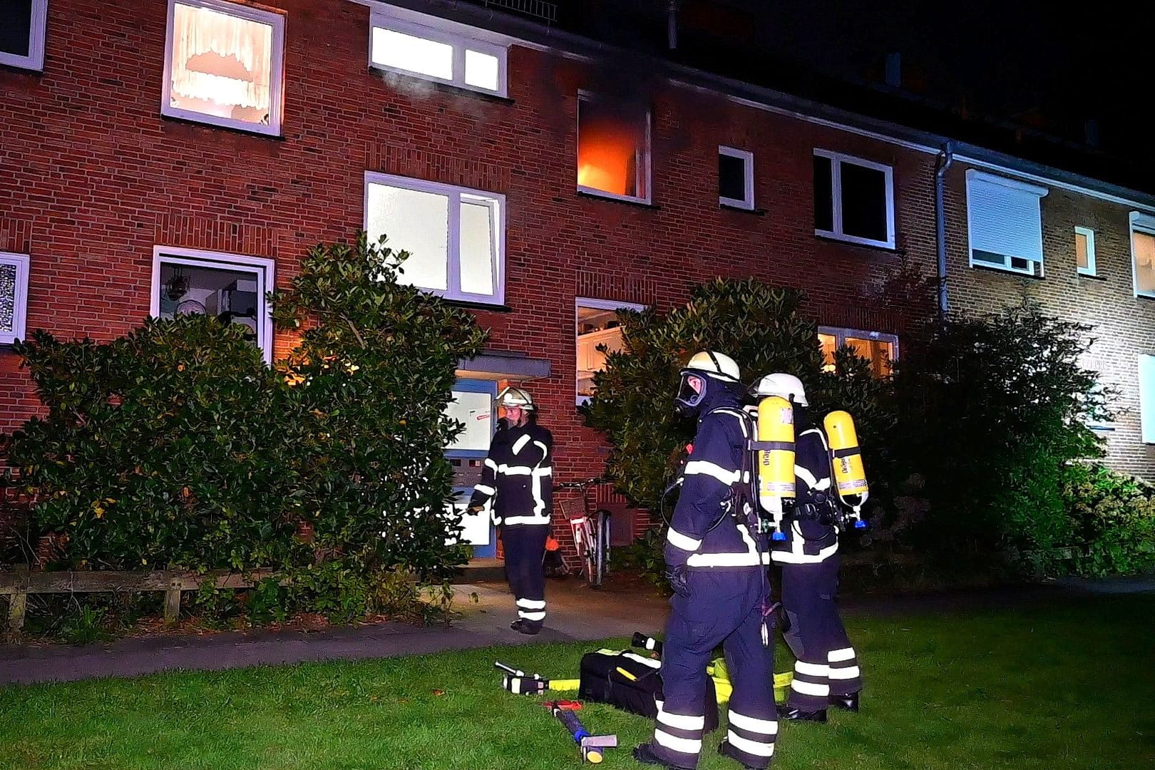 Feuerwehrleute vor dem Mehrfamilienhaus in Hamburg-Rahlstedt: Innerhalb weniger Stunden brachen zwei Brände in derselben Wohnung aus.