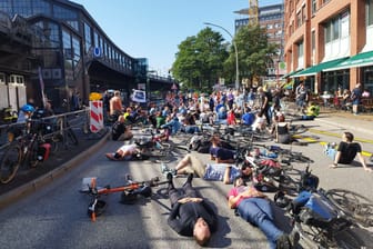 Teilnehmer der Mahnwache liegen auf der Straße Baumwall: Ein Lkw überfuhr hier vor mehr als einer Woche eine 71-Jährige.