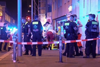 Feuerwehr und Rettungskräfte arbeiten an einem Tatort. Durch Schüsse sind drei Männer in Berlin-Schöneberg verletzt worden, einer von ihnen ist noch am Tatort gestorben.