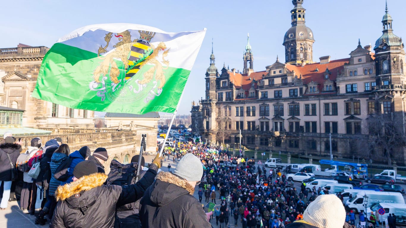 Ein Mann schwenkt eine Fahne des einstigen Königreiches Sachsen: Die Fahnen werden häufig von Anhängern der rechtsextremen Kleinstpartei getragen – und von der Partei selbst verkauft.