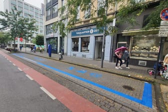 Die Venloer Straße: Die blauen Markierungen weisen auf die Wirtschaftszone hin.