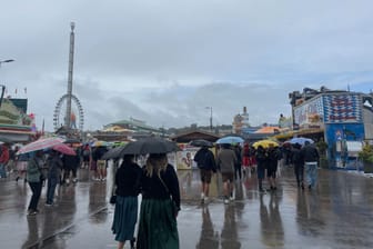 Regenschirme und Pfützen, so weit das Auge reicht: Am Wochenende ist es auf der Theresienwiese nass und kalt.