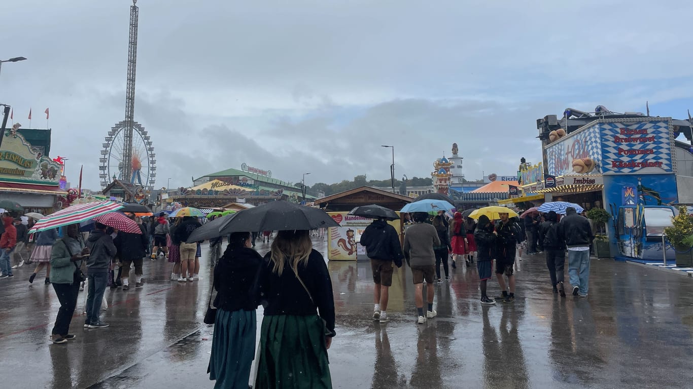 Regenschirme und Pfützen, so weit das Auge reicht: Am Wochenende ist es auf der Theresienwiese nass und kalt.