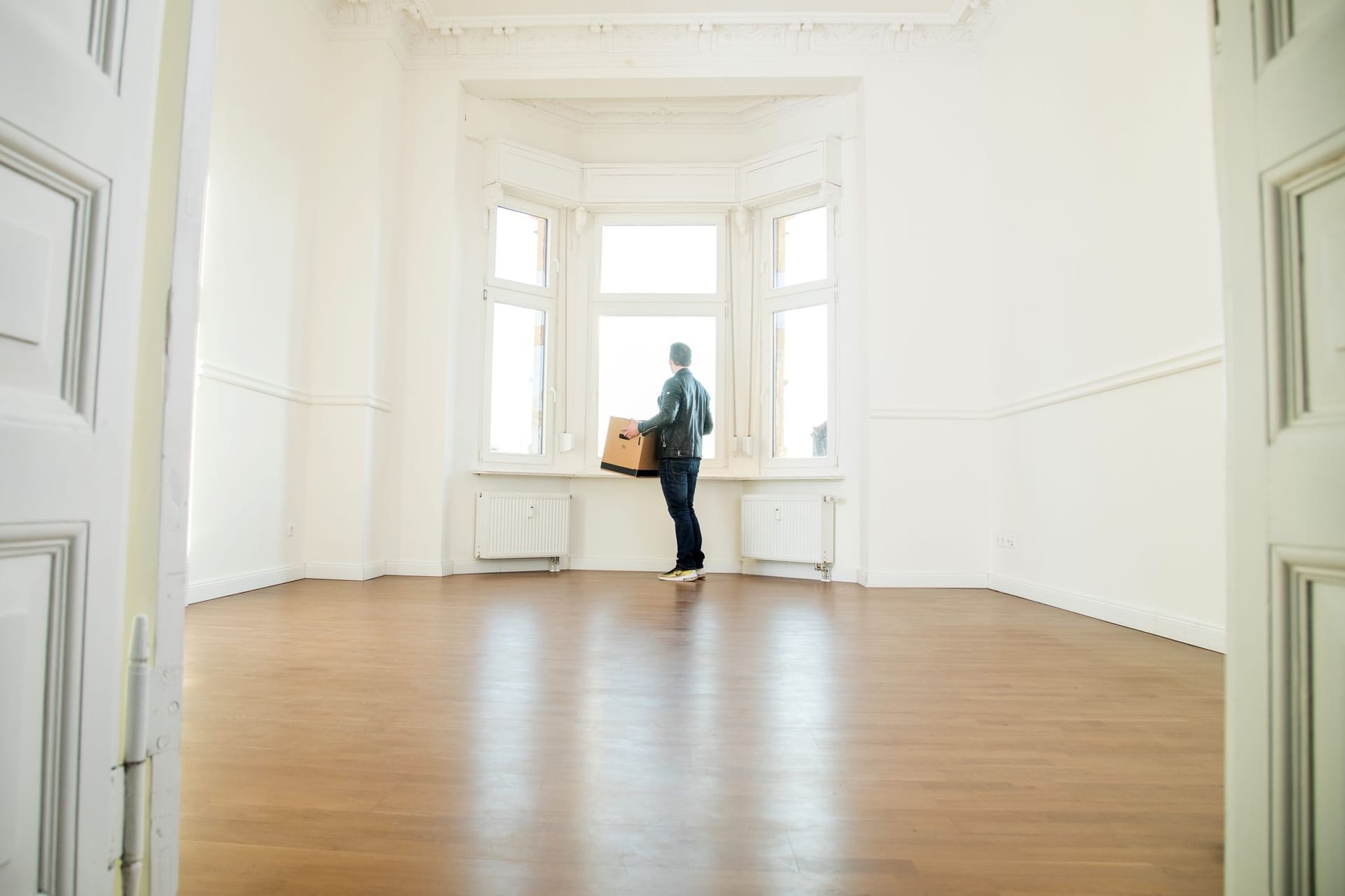 Mann mit Umzugskiste in einer Wohnung Mann mit Umzugskiste in einer Wohnung