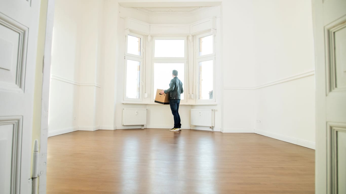 Mann mit Umzugskiste in einer Wohnung