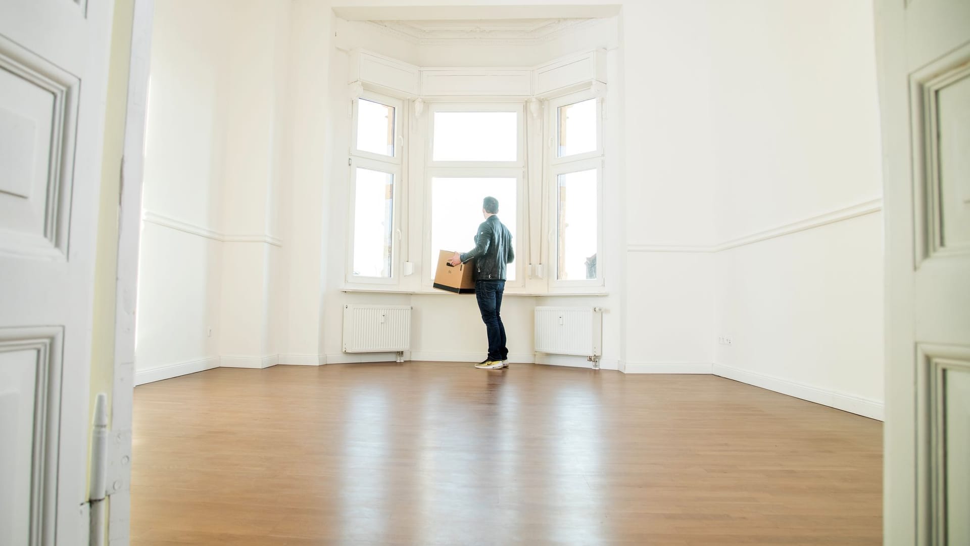 Mann mit Umzugskiste in einer Wohnung Mann mit Umzugskiste in einer Wohnung