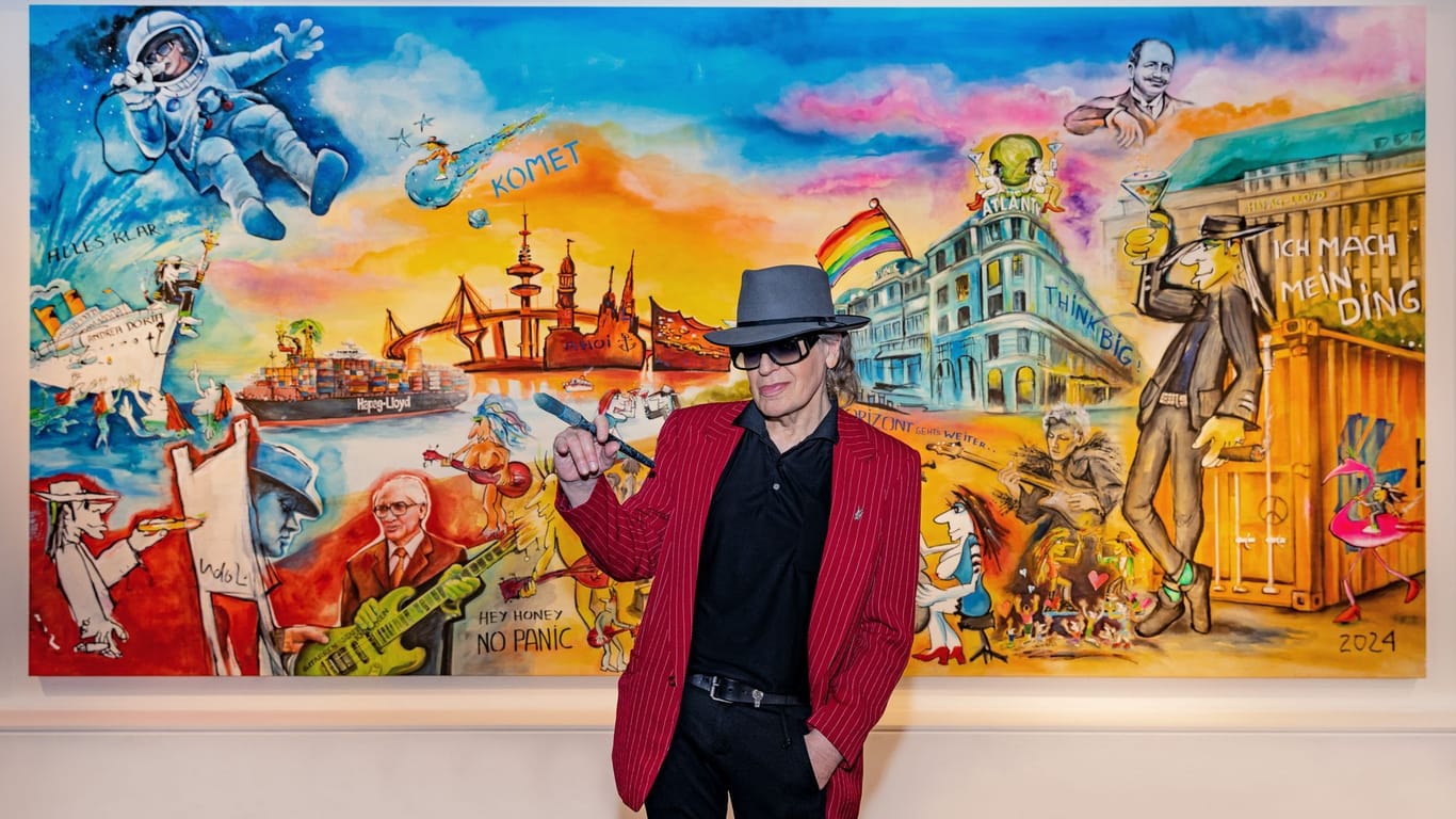 Der Musiker und Maler Udo Lindenberg steht mit einem Pinsel in der Hand vor seinem bislang größten Gemälde. Es misst 6 mal 3,5 Meter.