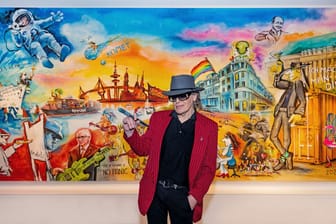 Der Musiker und Maler Udo Lindenberg steht mit einem Pinsel in der Hand vor seinem bislang größten Gemälde. Es misst 6 mal 3,5 Meter.