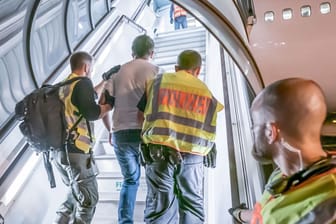 Polizeibeamte begleiten einen Afghanen auf dem Flughafen Leipzig-Halle in ein Charterflugzeug. (Archivbild)