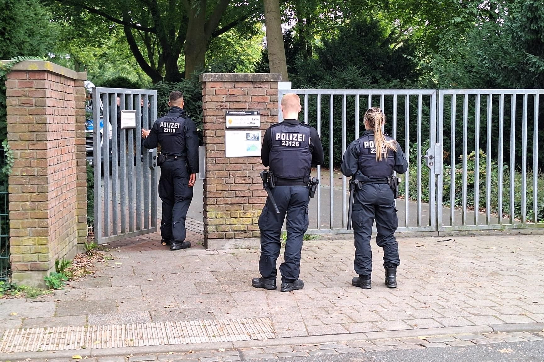 Polizisten stehen vor dem Waller Friedhof: Dort wurde der blutüberströmte Mann noch von Zeugen gesehen.