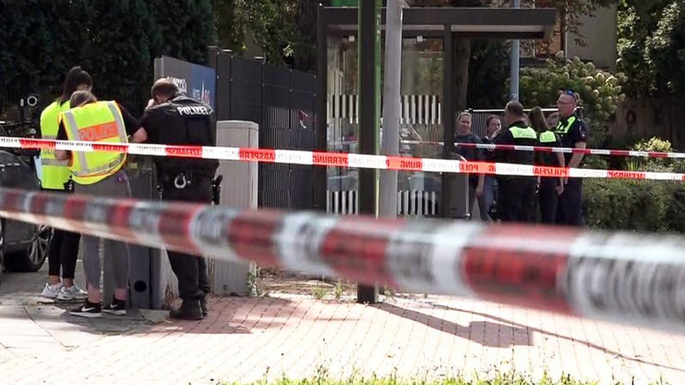 Polizisten stehen hinter Absperrband am Tatort im Bereich der Bahnhofstraße. Hier starb der 61-Jährige.