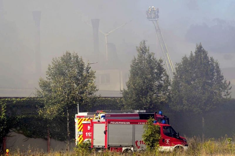 Feuer im Industriegebiet: Einsatzkräfte der Feuerwehr versuchen den Großbrand von einer Drehleiter aus zu löschen.