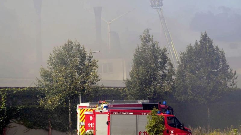 Feuer im Industriegebiet: Einsatzkräfte der Feuerwehr versuchen den Großbrand von einer Drehleiter aus zu löschen.