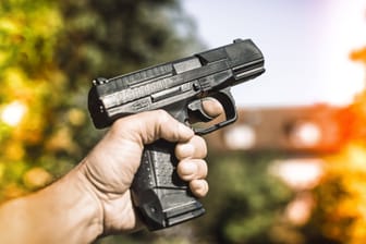 Männerhand mit Waffe, Waffengewalt