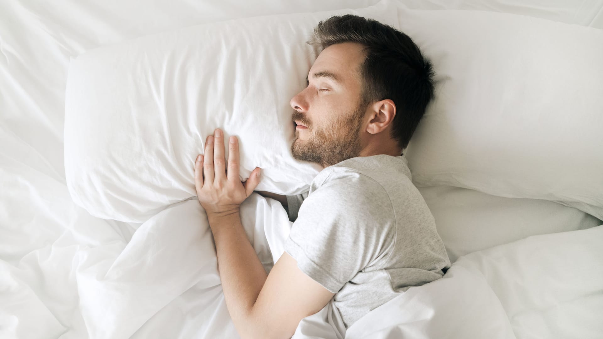 Ein Mann liegt im Bett und schläft