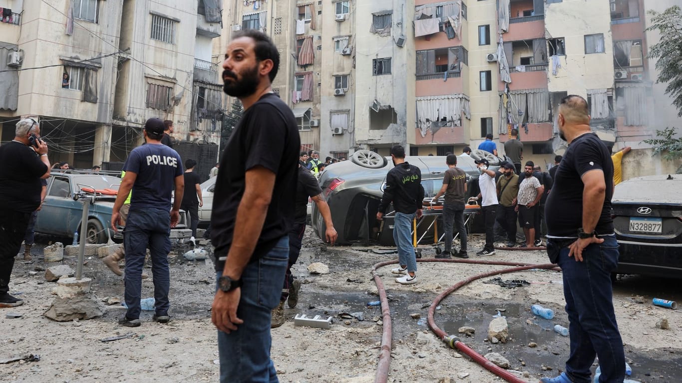 People inspect the site of an Israeli strike, in Beirut