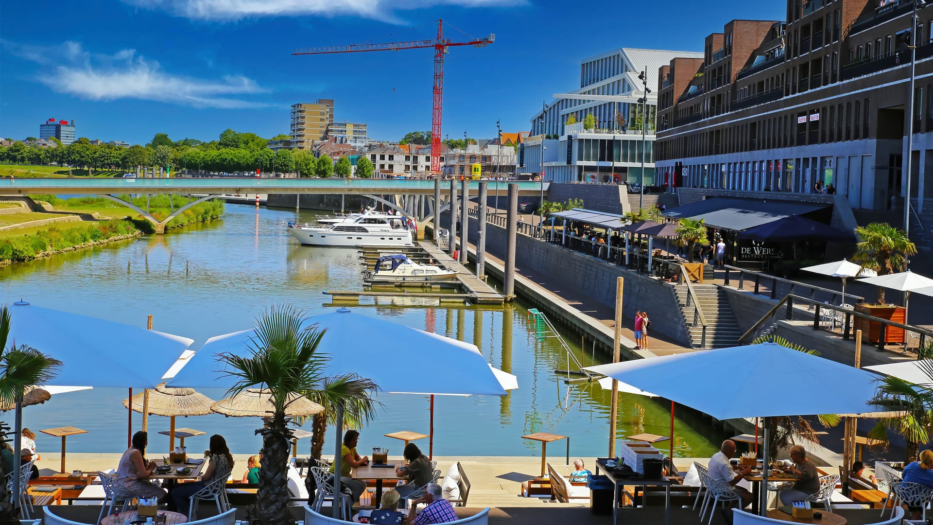 Venlo, Netherlands - July 9. 2022: View on modern dutch city harbor with exterior waterfront cafes and restaurants in summer