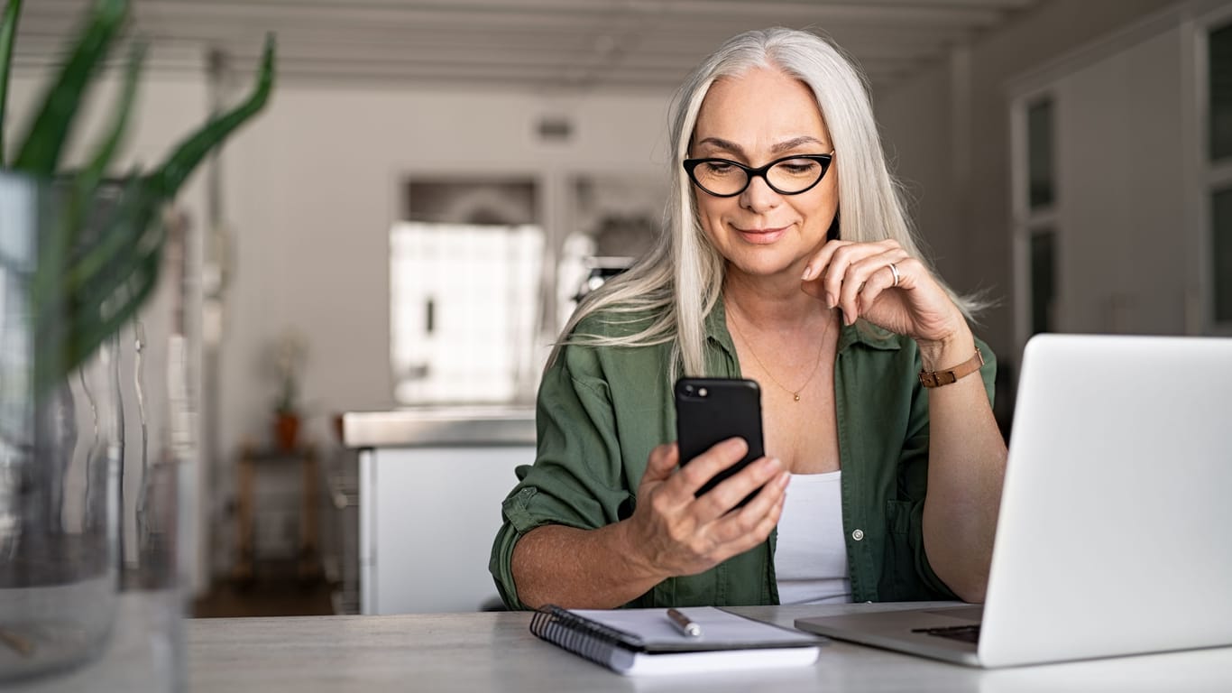 Frau mit Smartphone: Eine App auf dem Smartphone hilft Menschen mit Herz-Kreislauf-Beschwerden, ihre Risiken einzuschätzen.