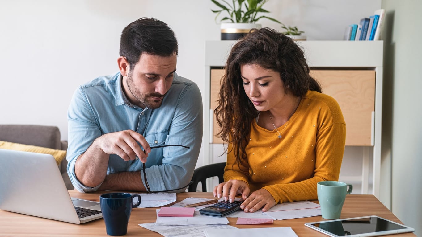 Paar sitzt am Tisch und managt seine Finanzen