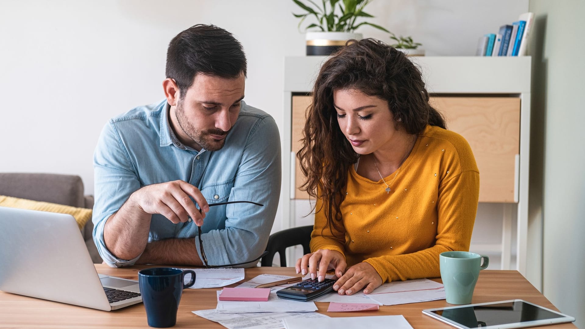 Paar sitzt am Tisch und managt seine Finanzen