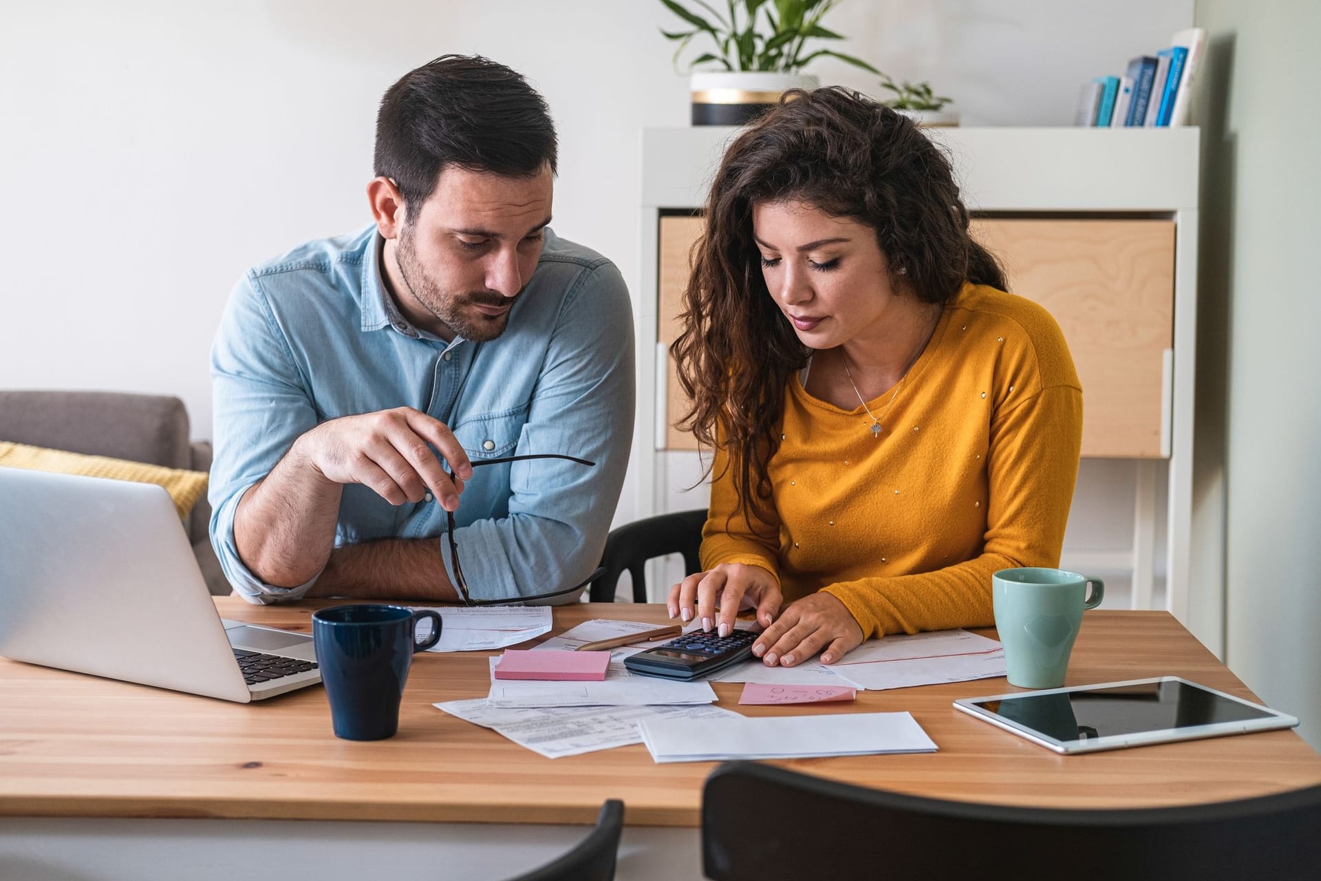 Paar sitzt am Tisch und managt seine Finanzen