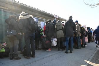 Geflüchtete warten vor einer Flüchtlingsunterkunft auf Einlass: Im Landkreis München sind die Behörden mit der Anzahl der Geflüchteten überfordert.