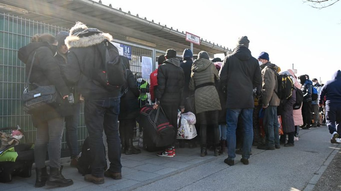 Geflüchtete warten vor einer Flüchtlingsunterkunft auf Einlass: Im Landkreis München sind die Behörden mit der Anzahl der Geflüchteten überfordert.