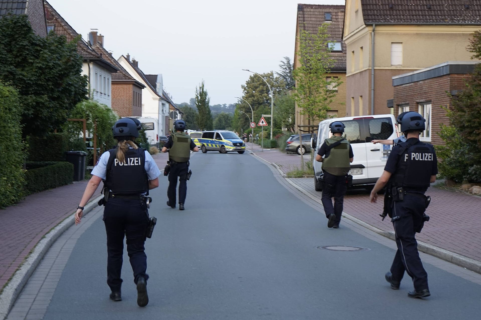 Polizisten gehen durch eine Straße der Kleinstadt Selm, wo zuvor ein Schuss gefallen und ein Mensch verletzt worden war.