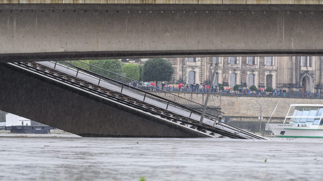 Schaulustige schauen sich die teilweise eingestürzte Carolabrücke am Sonntag an. Die Pegelstände der Elbe sind am Wochenende immer weiter gestiegen.