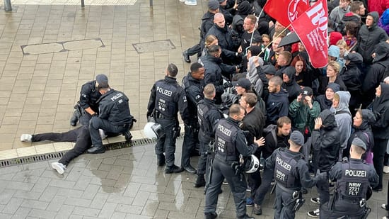 Police officers restrain a demonstrator.