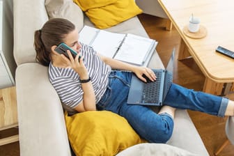 Eine Frau am Telefon und Laptop