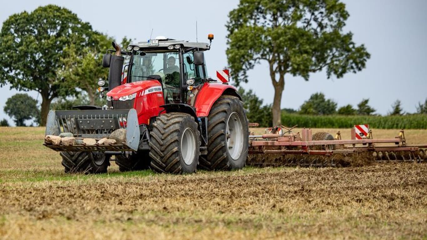 Ein Traktor fährt über ein abgeerntetes Feld auf einem landwirtschaftlichen Betrieb (Symboldbild).