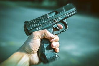 FOTOMONTAGE, Männerhand mit Waffe, Waffengewalt